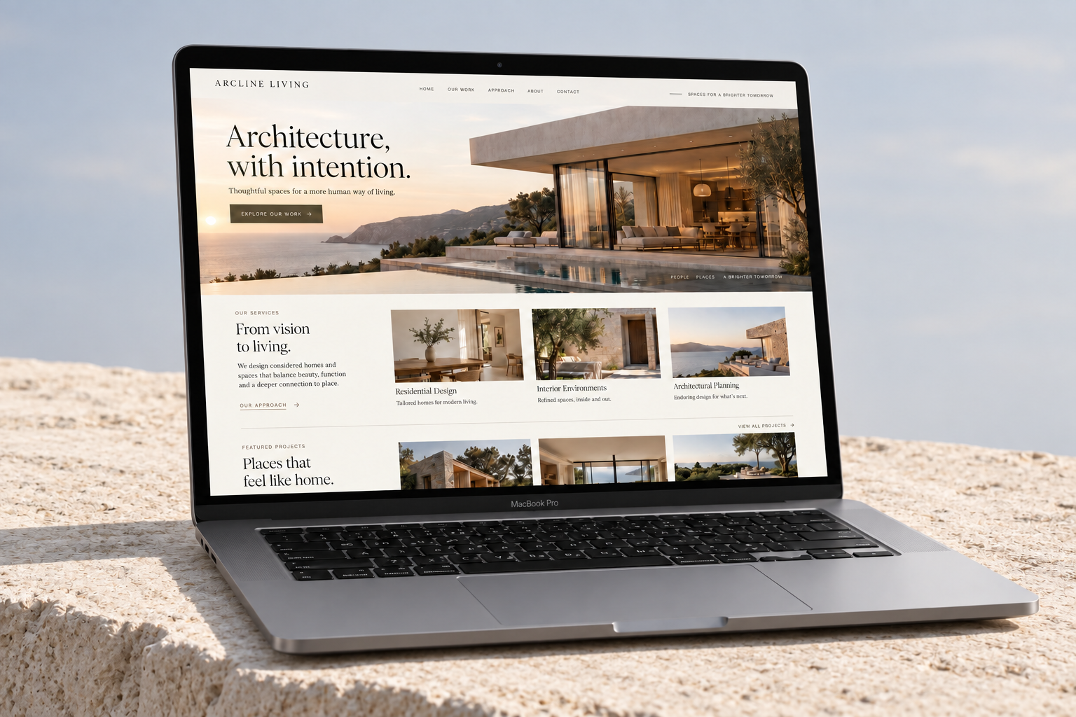 Arcline Living landing page displayed on a MacBook on a pale limestone ledge