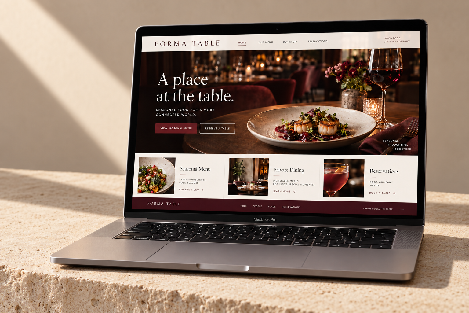 Forma Table landing page displayed on a MacBook on a pale stone slab with a diagonal daylight shadow